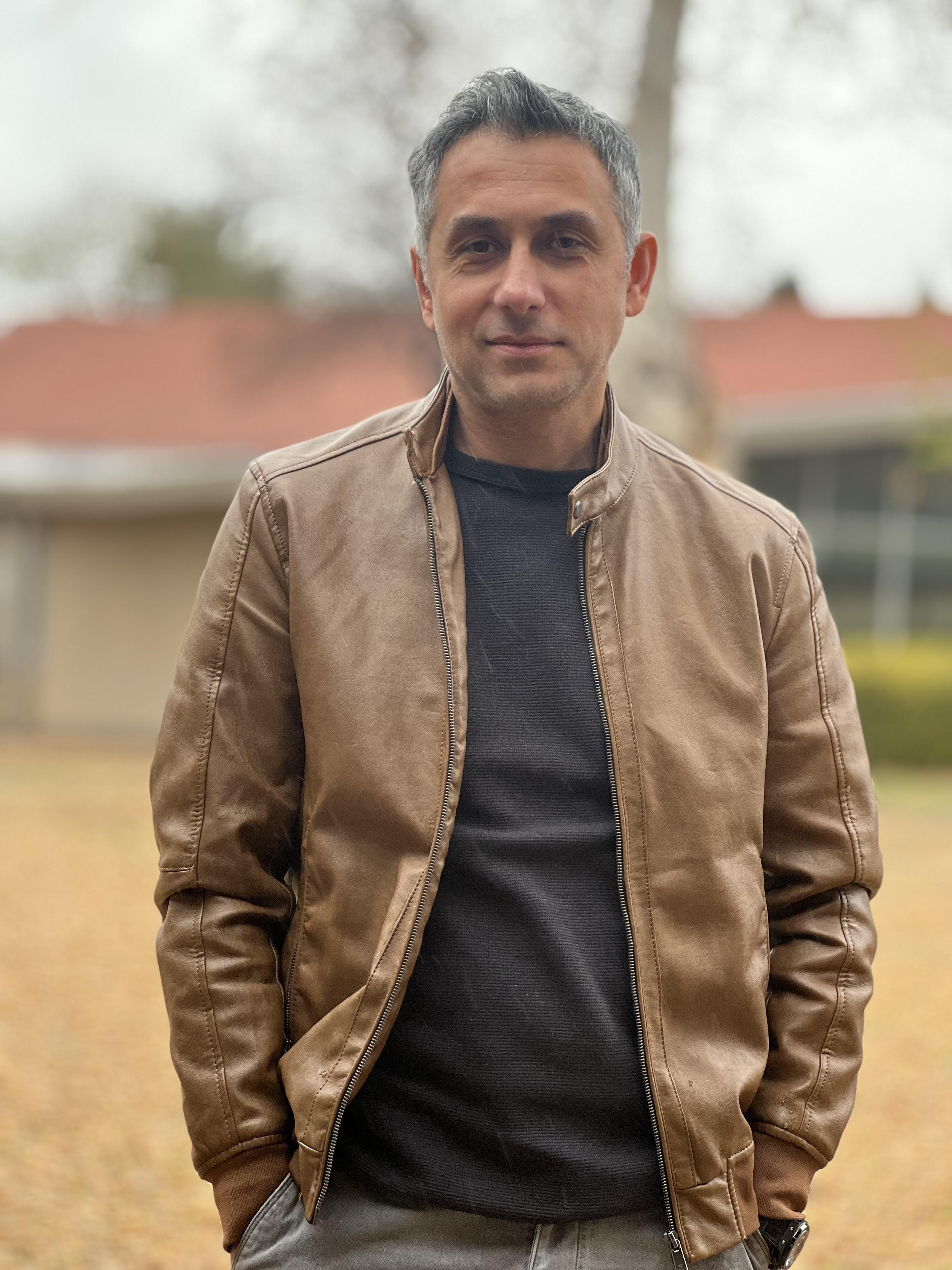 Portrait of ProLane Driving School's founder, standing outdoors in a brown jacket